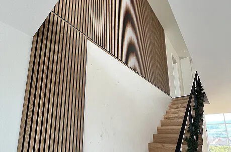 Treppenhaus mit dekorativer Akzentwand aus Holzlamellen in Freiamt