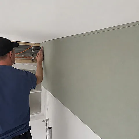 Montage einer gebogenen Gipskartonplatte für eine abgehängte Decke im Trockenbau