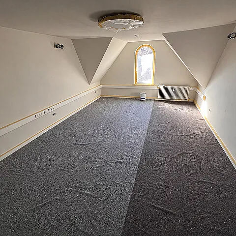 Frisch gestrichene Wände und Decke mit abgedecktem Boden während der Renovierung