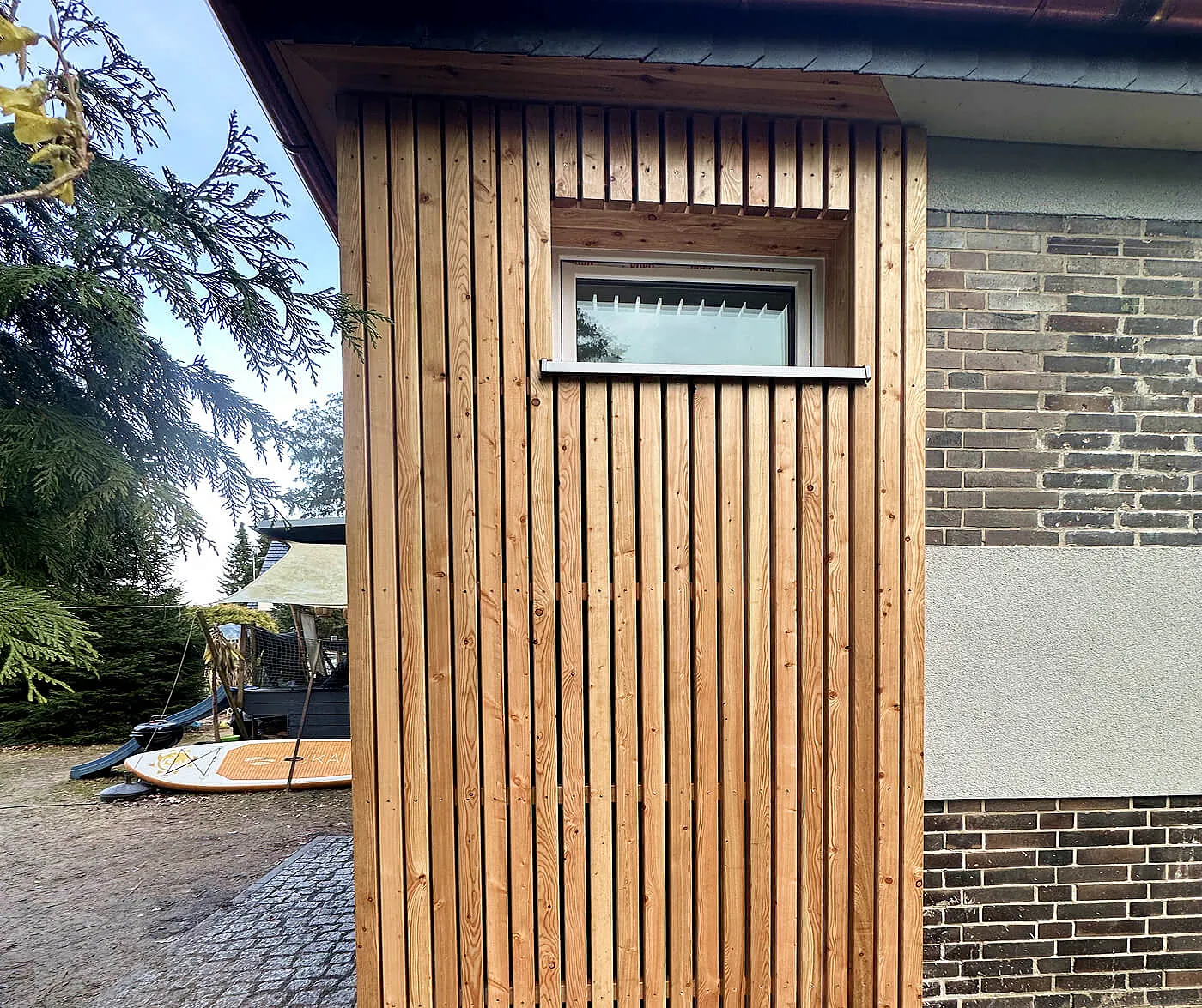 Holzwand-Konstruktion an der Fassadenseite eines Gebäudes in Berlin mit Fensterbereich